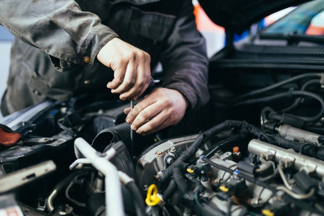 a mechanic working on a car in protective gear