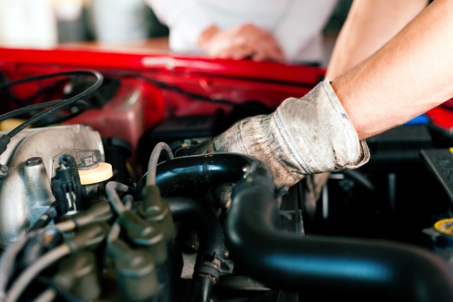 a mechanic working on a car in protective gear