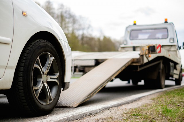 a car moving onto an tow truck ramp